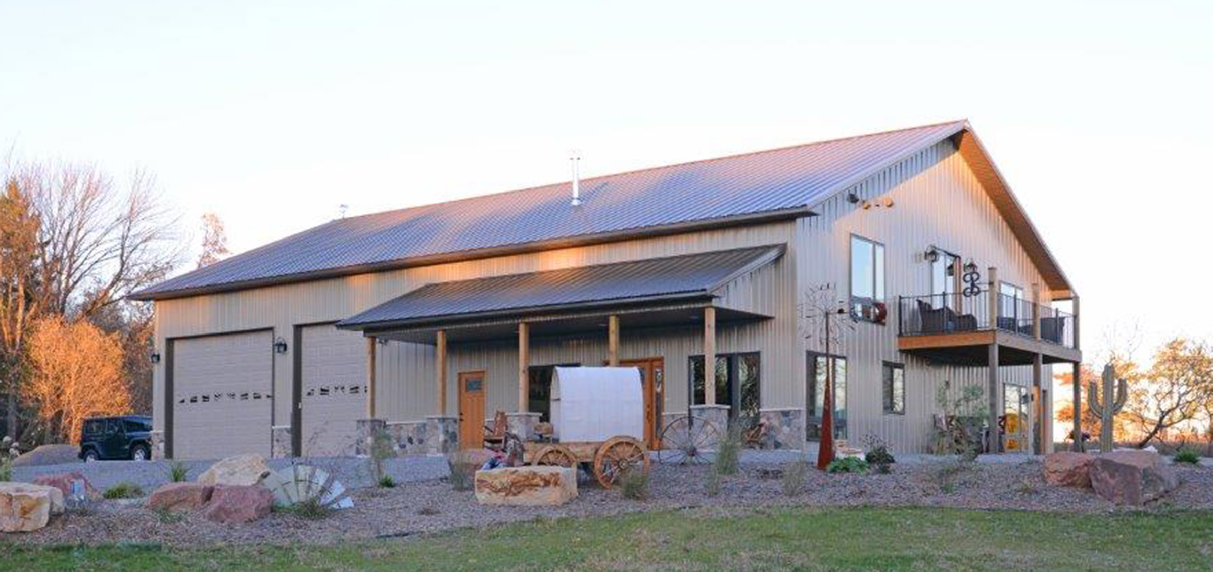 tan pole barn residential home with a old west decor and landscaping